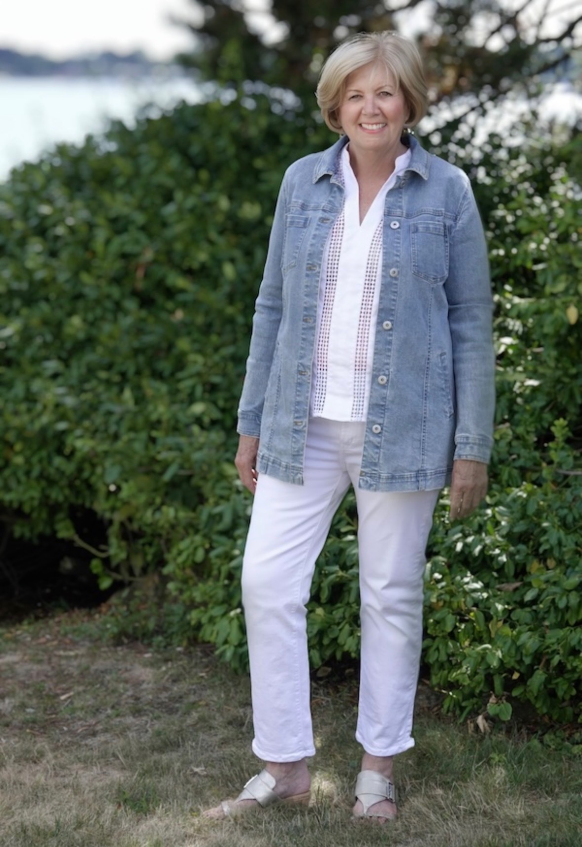 Gail Jones standing outdoors by the water in a denim jacket, smiling warmly
